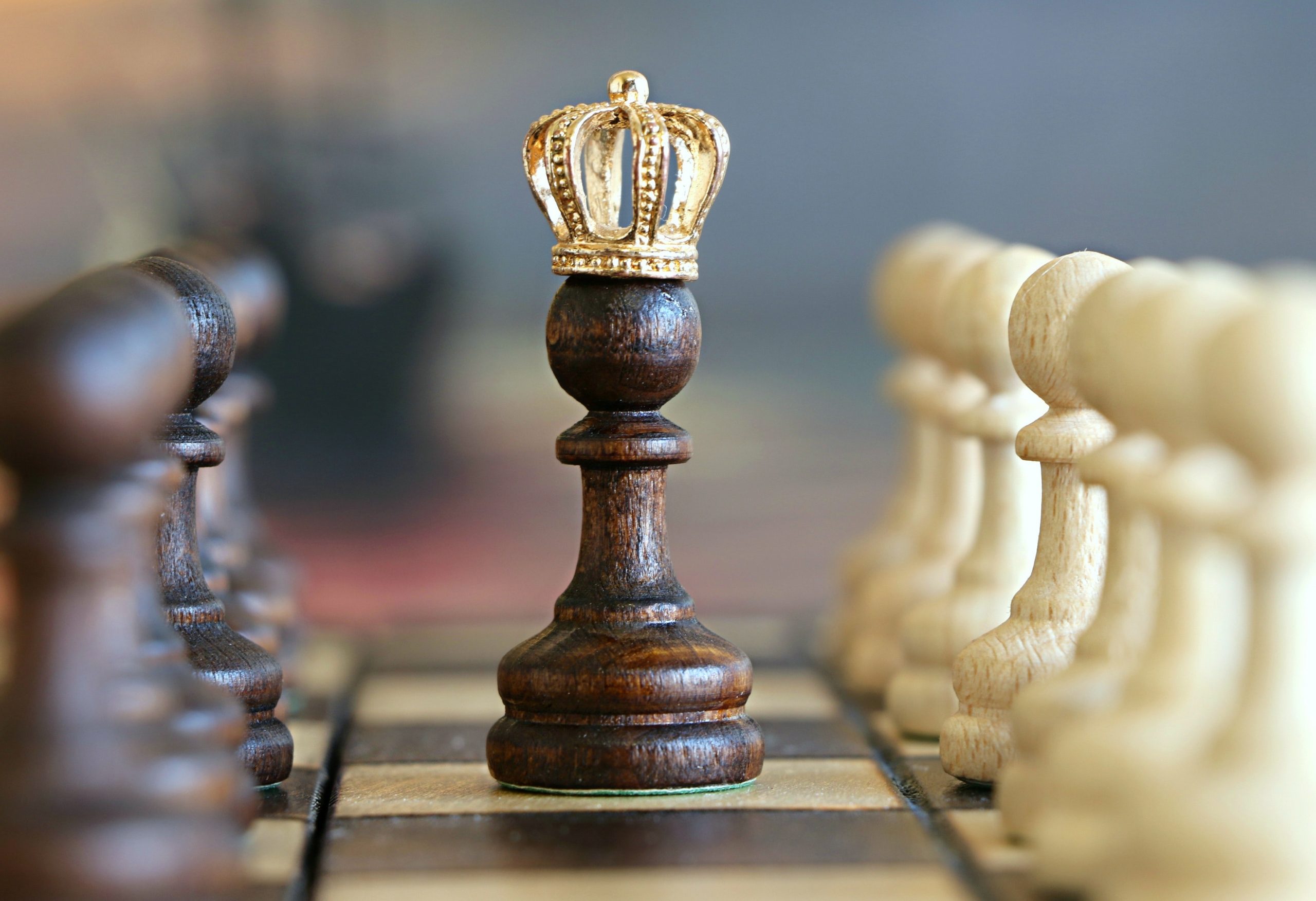 Chess pawn with a crown on its head