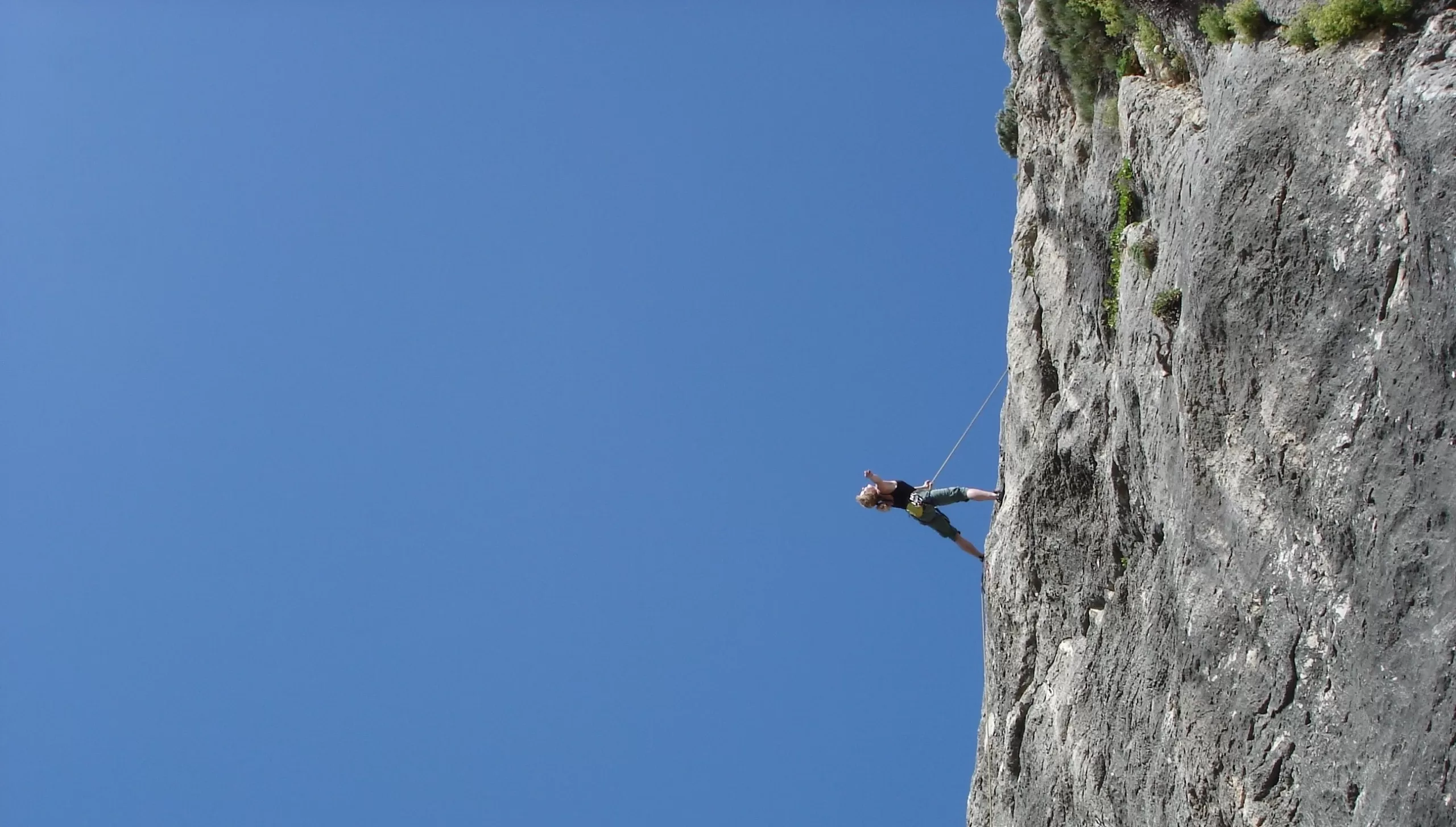 a person hanging from a cliff
