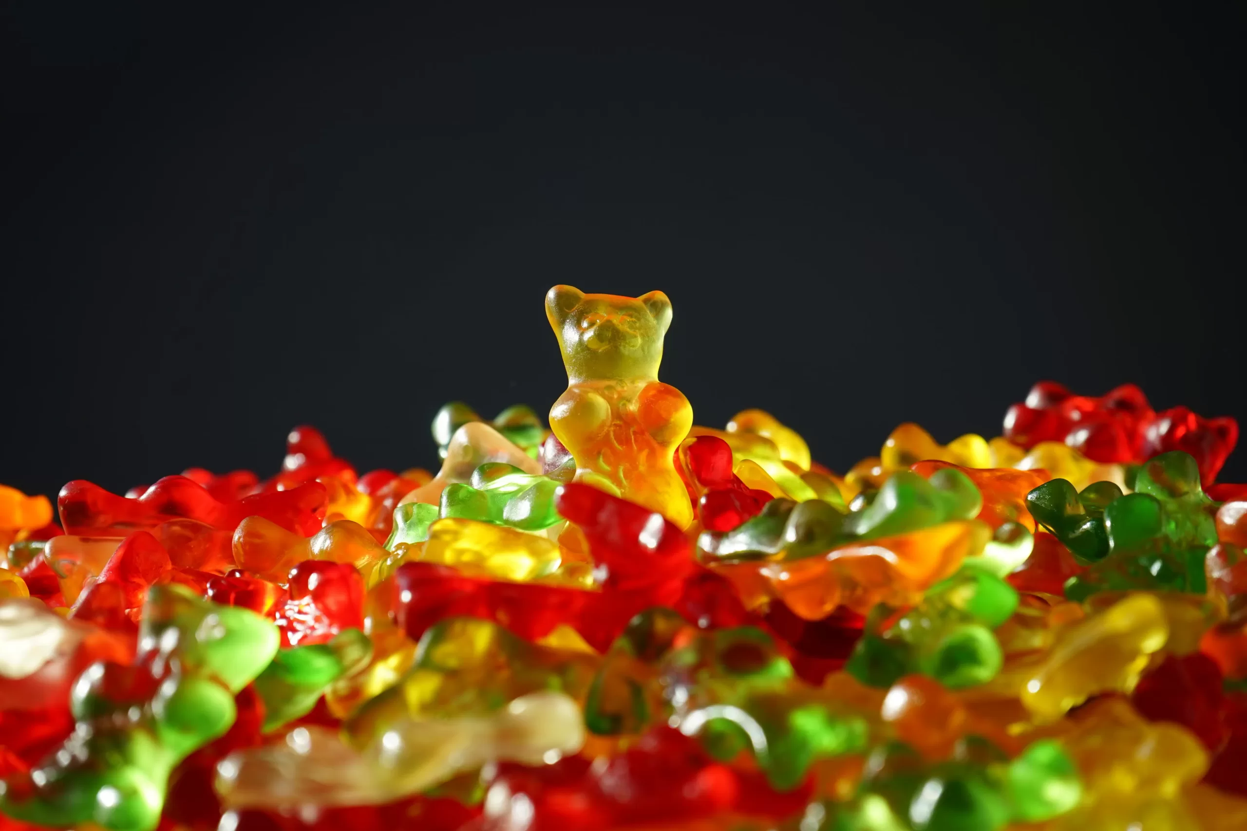 a pile of gummy bears with one standing above the rest