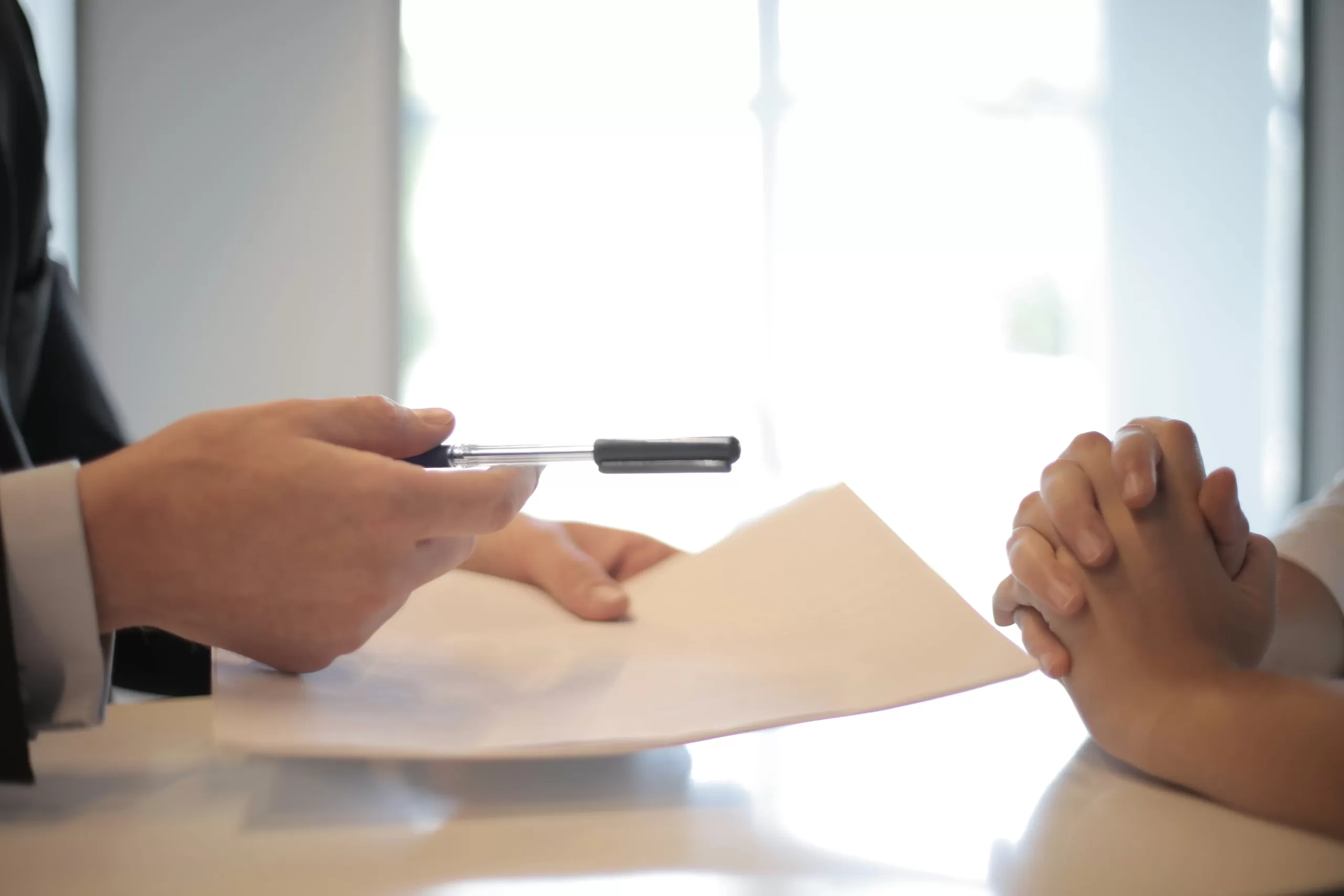 someone handing a pen to another person