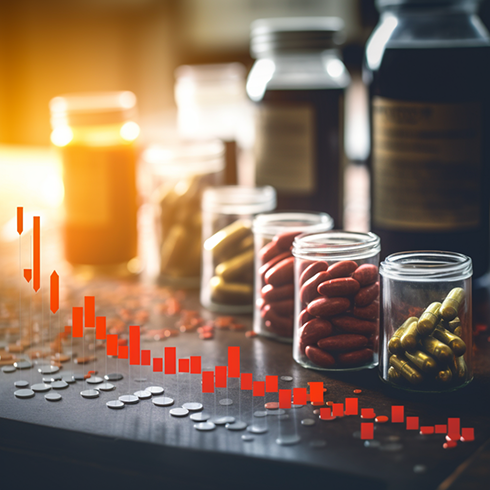 Bottles of pills behind an investing graph.